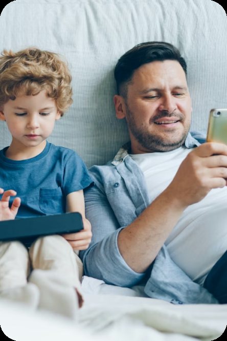 A parent checking their phone by a child's bedside at night